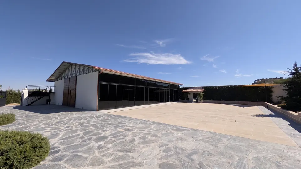El hangar visto desde la explanada, con su gran cristalera y el portón de madera