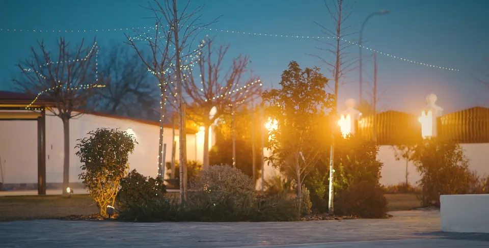Guirnaldas de luz sobre los jardines al anochecer