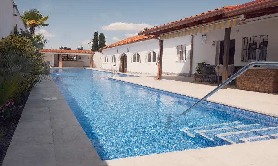 La piscina de la finca con la casa principal de fondo