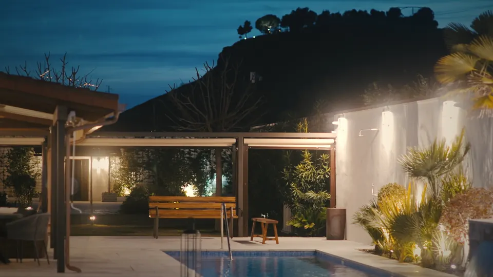 La piscina y el porche al caer la noche