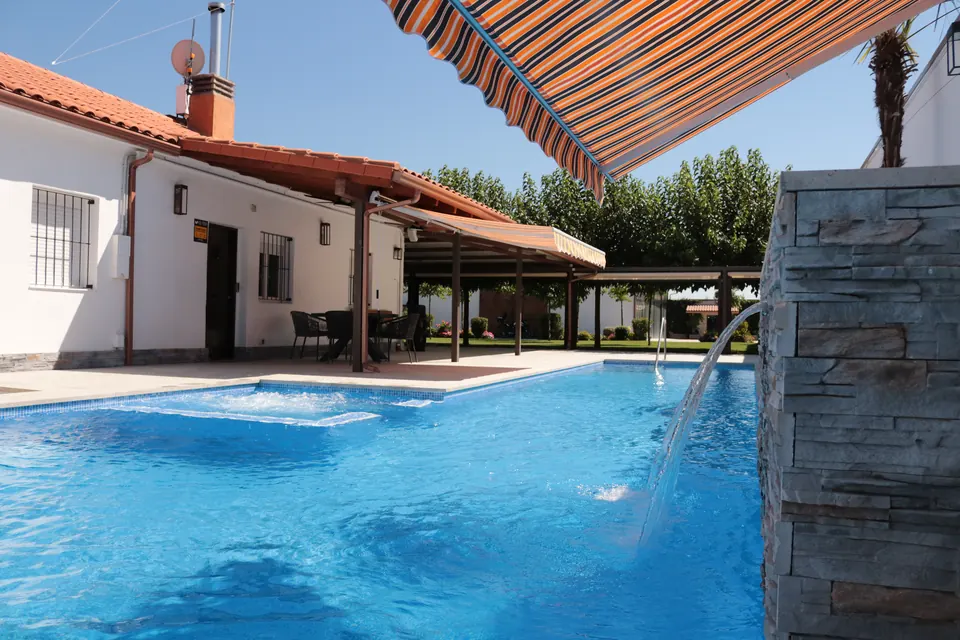 El spa integrado en la piscina, burbujeando bajo el toldo de rayas