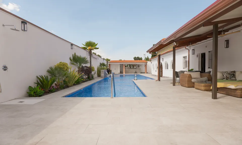 La piscina con la zona de estar cubierta